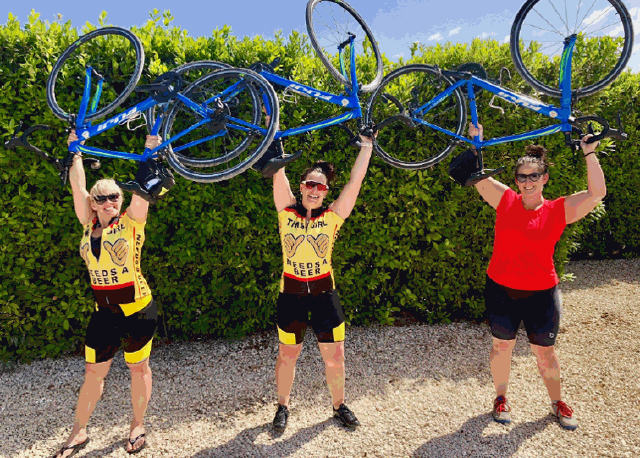 ladies with bikes held in air